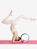 woman in a headstand using the Yoga Wheel by Capezio